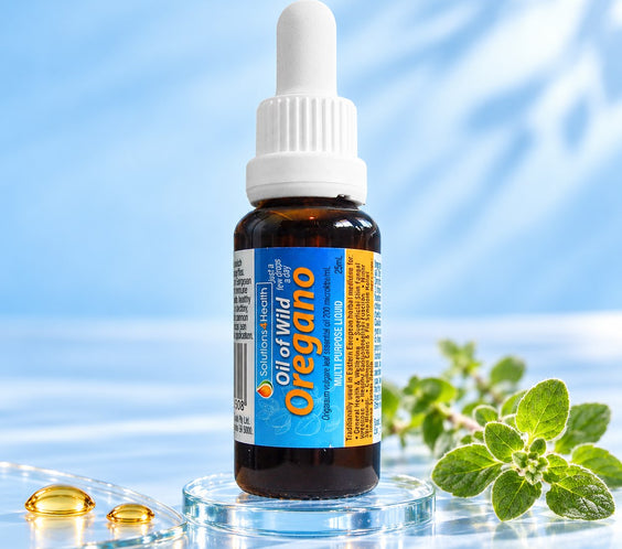 Solutions4Health Oil of Wild Oregano 25ml bottle on a glass base with fresh oregano and golden oil droplets against a light blue background.

